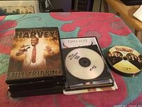 Stack of DVDs including Steve Harvey's Still Trippin' and a handwritten labeled disc for 'This is It'