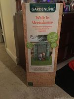 Photo of the boxed Gardenline walk-in greenhouse showing dimensions and features on the packaging.