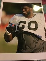 Glossy photograph of Cosey Coleman in Browns practice gear holding a drink, smiling