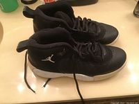 Side view of the black Nike Retro Jumpman Pro GS sneakers showing the white Jumpman logo on the heel area and white rubber sole.