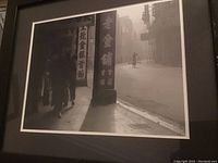 Framed black and white print showing an Asian street with pedestrians and signage.