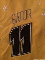 Close-up image of yellow jersey with Gator #11 embroidered on back.
