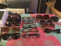 Photo of multiple women’s sunglasses and reading glasses arranged on table
