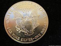 Reverse of 1990 American Silver Eagle coin showing heraldic eagle with shield, olive branch, arrows, 13 stars, and inscriptions.