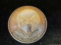 Reverse side of 1994 American Silver Eagle coin showing heraldic eagle design and inscriptions.
