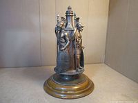 Overall front view of the cast metal sculpture on wooden base