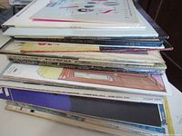Stack of vintage LP record albums, showing the thickness and varying colors of album covers.