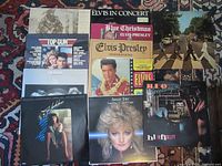 Photo showing front covers of 12 vintage LP record albums, including The Beatles Abbey Road, multiple Elvis Presley albums, Queen, REO Speedwagon, Bonnie Tyler, Top Gun soundtrack, and others.