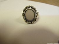 Front view of vintage silver ring with oval pale purple stone on a white background.