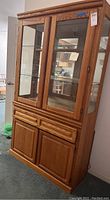 Front view of oak china hutch with glass doors and drawers