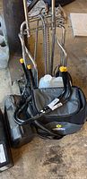 Photo of a folding luggage cart with chrome frame and black fabric bag with sunflower logo