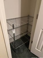 Full view of the 3 tier chrome wire rack shelving unit in a corner, showing its structure and size.