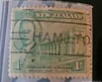 Close-up photo of a green 1 cent postage stamp from New Zealand with a Hamilton postmark and no visible damage on the edges.