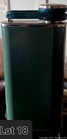 Side view of the green textured steel Stanley flask with hinge top cap securely attached.