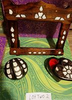 Wooden picture frame with mother of pearl inlay and two matching jewelry boxes displayed on a patterned surface.