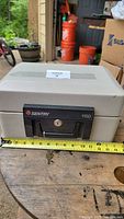 Front view of Sentry Safe 1150 showing lock, keys, and tape measure for size reference.