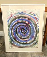 Full view of framed abstract watercolour painting showing spiral design in multiple colors, signed lower right.
