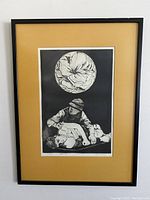 Full framed view of the etching showing the artwork with the tan mat and thin black frame.