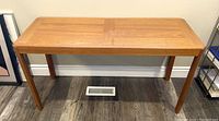 Front view of vintage teak Danish console table showing rectangular top surface and four legs.