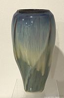Front side view of the tall tapered ceramic vase with multicolored glaze