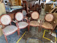 Four matching upholstered armchairs arranged in a row, showing entire chairs and floor setting.