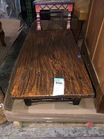 Top and side view of the rectangular wood coffee table showing the grain, scratches, and marks on the surface and legs.