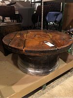 Full side-angle view of the coffee table showing the circular wooden cable spool top and whiskey barrel base.