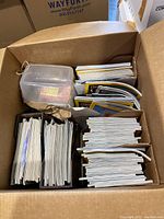 Box filled with neatly stacked magazines of various titles.
