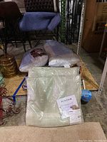 Photo of bath sheets and pillows wrapped in plastic packaging arranged on a platform