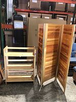 Photo of the wood shelf with three shelves and the folding wood room divider standing next to each other.