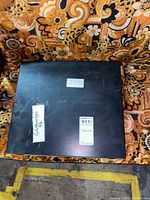 Closed black carrying case for the Brother electric typewriter with some labels on the top surface.