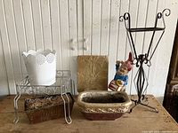 Full view of 7 garden decor pieces including various planters, garden gnome, metal plant stand and lantern, and stone plaque.