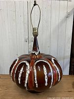 Full view of the large ceramic Mid Century Modern table lamp on wooden surface with white background.