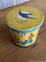 Top view of yellow tin lid with blue bird and 'Blue Bird Toffees' text.