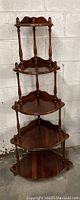 Full view of the wooden whatnot corner shelf showing five tier design and varnished brown finish.