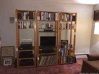 Full view of the 3-piece wooden book and media shelf set in room with books, media equipment, and vinyl records on shelves.