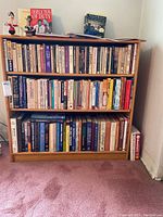 Full front view of oak bookcase filled with books and decorative items on top. Close view showing condition and contents not included as per seller.