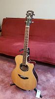 Full view of Yamaha APX-500II electric acoustic guitar on stand showing natural wood finish and overall condition.