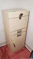 Full view of beige metal file and storage cabinet with lock and key.