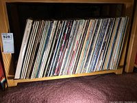 Wooden shelf filled with upright vinyl LP jackets