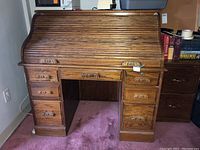 Closed roll top desk showing wood finish and drawer layout