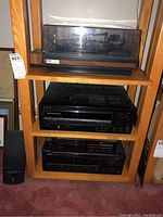 Shelf showing turntable on top, stereo receiver in middle, and tape player on bottom
