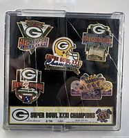 Green Bay Packers Super Bowl XXI Champions limited edition pin set showing 5 pins in a cracked plastic display case with edition number 3174 of 5000.