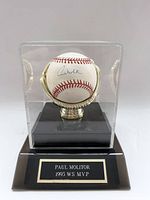 Front view of Paul Molitor signed baseball in clear acrylic display case with black base and gold glove holder. Plaque on base reads 'PAUL MOLITOR 1993 WS MVP.'