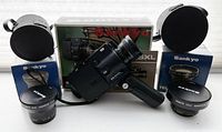 Sankyo ES-44XL Super8 camera with original box in background, two converter lenses with boxes and carrying cases arranged around it