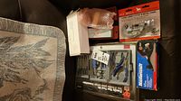 Overall photo of the unopened tool kit, tubing cutter boxed in red with Pitt Bull branding, sharpening stone in white box, and block plane.