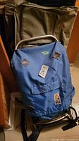Photo showing vintage blue Conquest hiking backpack with aluminum frame in front of a green Samsonite luggage bag.