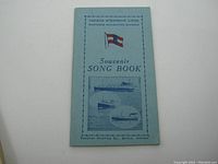 Front cover of the 1920s Canada Steamship Lines souvenir song book showing the title, company name, and images of steamships against a blue background.