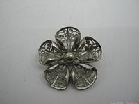 Front view of the sterling silver filigree flower brooch showing detailed filigree petals and central dome.