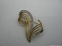 Front view of the Boucher brooch showing gold-tone loops and clear rhinestones.